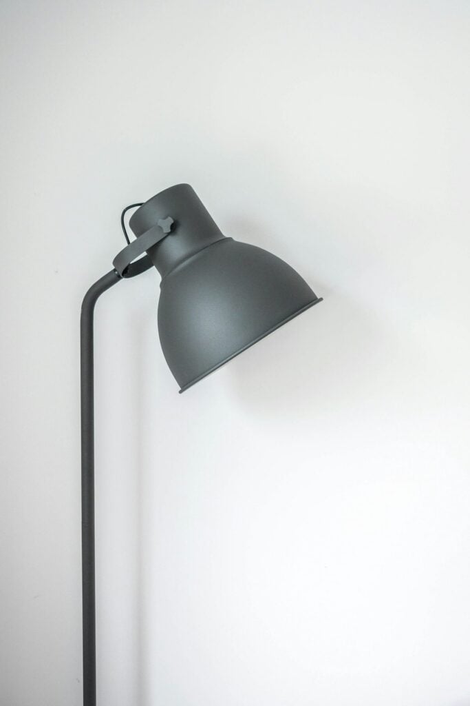 Warm ambient glow from sculptural ceramic smart lamp casting soft amber light across wood room