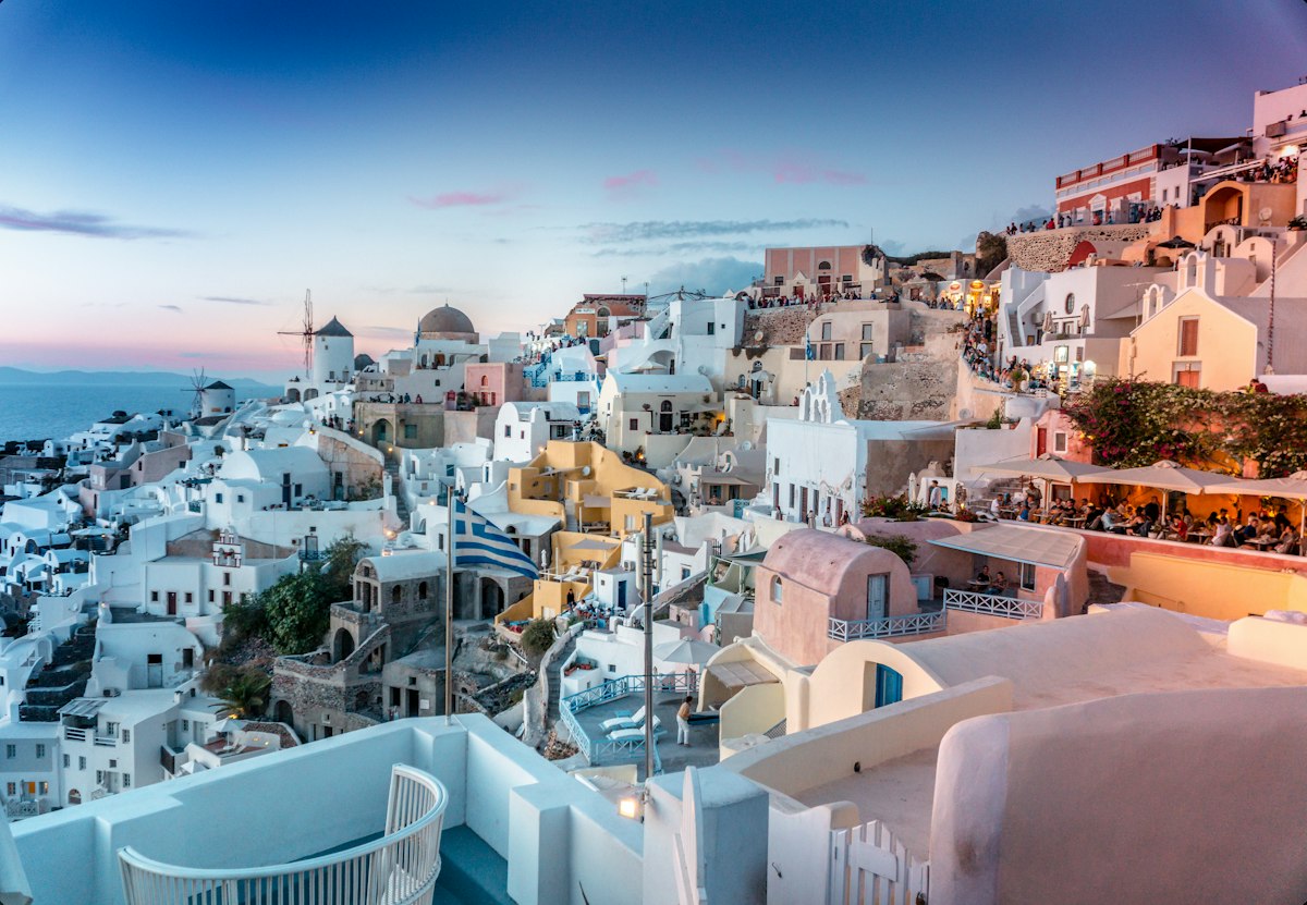 Iconic whitewashed Santorini caldera villas with sapphire domes overlooking the Aegean sea